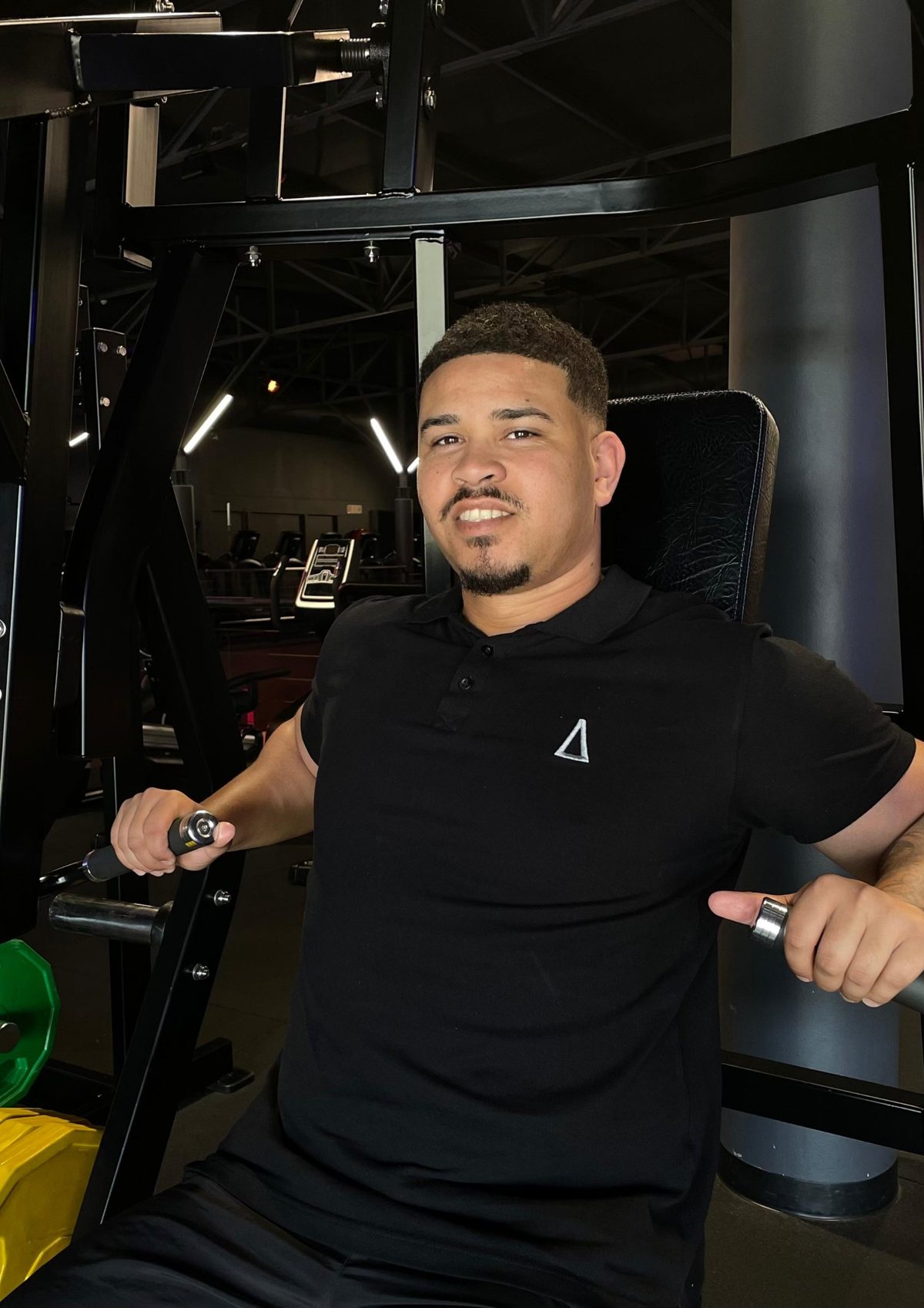 Kyle, OVRcome coach, seated on a machine in the gym